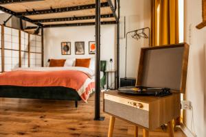 Schlafzimmer mit einem Bett und einem Flachbild-TV in der Unterkunft Klassen Stay - Exklusives Loft - XXL Leinwand - 4 km Messe, 1,5 km HBF in Essen