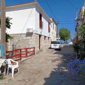 a white house with a car parked on a street at Agapis Apartments in Petra
