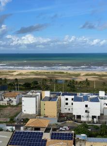 un groupe de bâtiments avec des panneaux solaires et l'océan dans l'établissement Aptos atrás da Passarela do Caranguejo, à Aracaju
