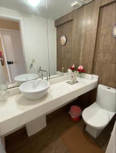 a bathroom with a sink and a toilet and a mirror at Aptos atrás da Passarela do Caranguejo in Aracaju