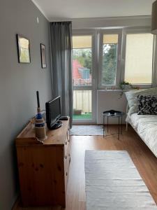 a living room with a couch and a desk with a television at Apartament Dobre Miejsce in Malbork