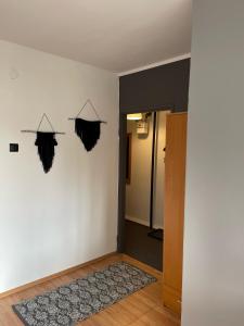 a room with a white wall and a door with a rug at Apartament Dobre Miejsce in Malbork