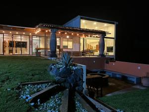 a house at night with a fountain in front of it at Rancho Emisajumi El Ajusco in Mexico City