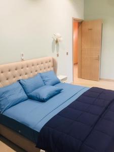 a blue bed with blue pillows in a bedroom at Oasis Lawafossi in Bobo-Dioulasso