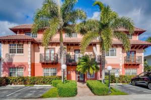 a pink building with palm trees in front of it at Beach 2 level spacious condo in Fort Lauderdale
