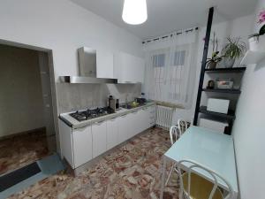 a kitchen with a stove and a table in it at Affittacamere 24H in Civitanova Marche