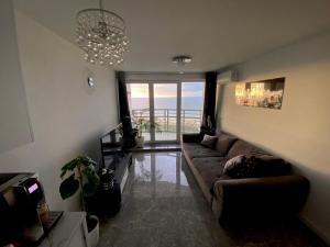 - un salon avec un canapé et une vue sur l'océan dans l'établissement Widok na Morze Porta Mare - Apartament 326, à Dziwnówek