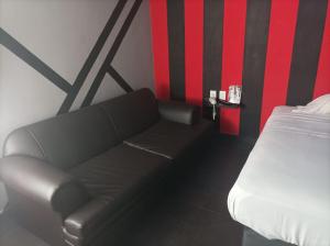 czarna kanapa w pokoju z łóżkiem w obiekcie La Selva Auto Hotel ADULTS ONLY w mieście Soncuantla
