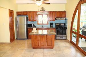 a kitchen with wooden cabinets and a stainless steel refrigerator at Secluded Ocean Front Overlooking the Marina in San Carlos