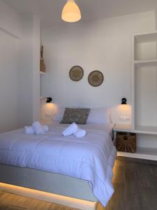 a bedroom with a white bed with two pillows at Juli’s Suites in Mérikhas