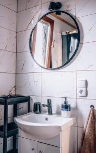 a bathroom with a sink and a mirror at Górskie Chatki Krysi i Piotrka in Stronie Śląskie