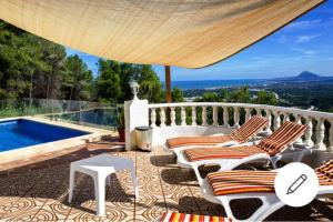 eine Terrasse mit Stühlen und einem Pool in der Unterkunft BELLAVISTA 9 in Oliva