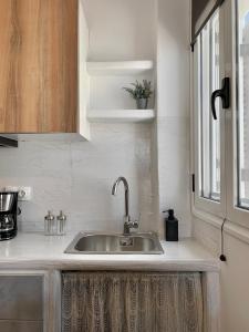 um balcão de cozinha com um lavatório e uma janela em Juli’s Suites em Mérichas