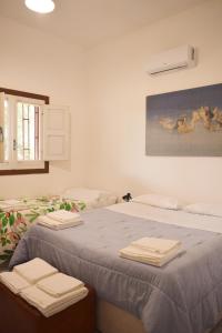 Habitación con cama y toallas plegables. en La Cecia - Casa vacanze nella campagna salentina, en Cavallino di Lecce