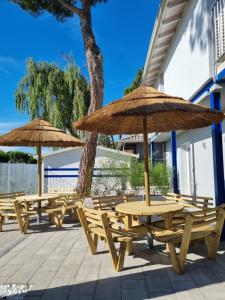 a group of picnic tables and umbrellas on a patio at Blue Inn Residence e B&B in Lido delle Nazioni