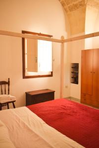 um quarto com uma cama grande e um cobertor vermelho em La Cecia - Casa vacanze nella campagna salentina em Cavallino di Lecce