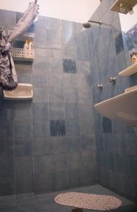 uma casa de banho com um chuveiro com azulejos azuis em La Cecia - Casa vacanze nella campagna salentina em Cavallino di Lecce