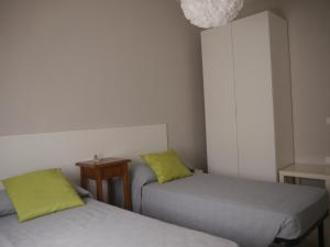 two beds in a small room with yellow pillows at Domus Tilla in Piombino +9 photos