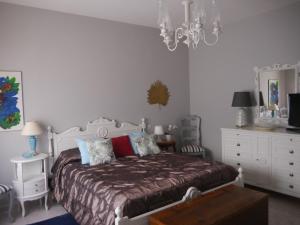 a bedroom with a bed and a chandelier at Domus Tilla in Piombino