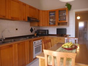 a kitchen with wooden cabinets and a bowl of fruit on a table at Domus Tilla in Piombino