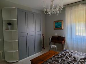 a bedroom with a bed and a desk and a chandelier at Domus Tilla in Piombino