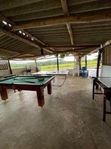 a room with three ping pong tables in it at Chácara recanto Feliz in Pirenópolis