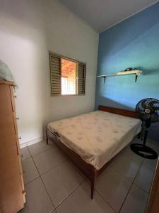 um quarto com uma cama num quarto com uma janela em Chácara recanto Feliz em Pirenópolis