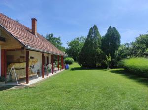 una casa con un prato accanto a un edificio di BB House a Balatonboglár
