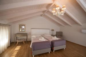 a bedroom with two beds and a table and a chandelier at Kampos Apartment in Vasiliki