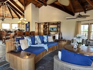 a living room with blue couches and tables at Villa Serenity in San Pedro