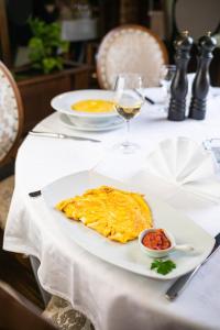 a white plate with an omelet on a table at Stara Ada Banja Luka in Banja Luka