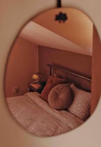 a mirror reflecting a bed with a pillow on it at Mansard underneath the stars 