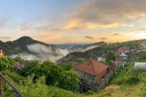 a village in the mountains with clouds in the valleys at Mansard underneath the stars in Pripek