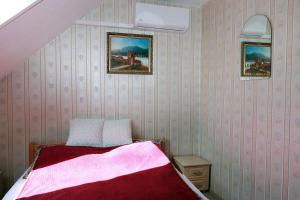 una camera con un letto e due quadri appesi al muro di Arany Dió Fogadó a Eger