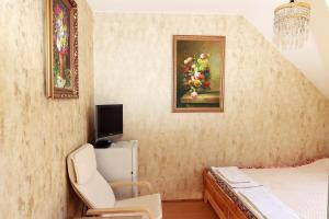 une chambre avec une chaise et une peinture de fruits dans l'établissement Arany Dió Fogadó, à Eger