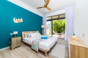 a bedroom with a bed and a blue wall at Blue Residences- Ground floor two bedroom apartment in Grand Baie