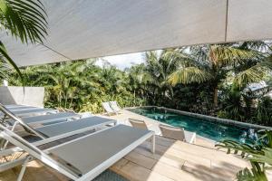 a patio with chairs and a swimming pool at Blue Residences- Ground floor two bedroom apartment in Grand Baie