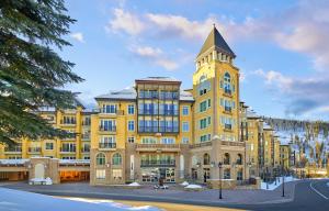 a large yellow building with a clock tower at The Vail Collection at the Ritz Carlton Residences Vail in Vail