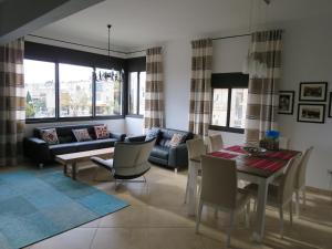 sala de estar con sofá, mesa y sillas en Apartment Haifa, en Haifa