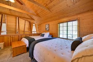 Un dormitorio con dos camas en una cabaña de madera. en A-Frame Munds Park Retreat 35 Miles to Snowbowl, en Munds Park