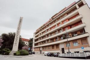 a large building with a monument in front of it at Vittoria Suite in Campobasso