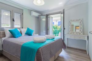 a bedroom with a bed with blue pillows and a mirror at Dion apartment in Lygia