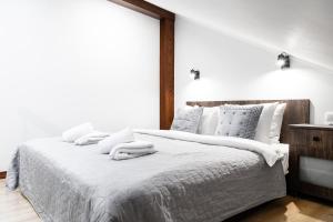 una camera bianca con un grande letto con asciugamani di HOUSEHOST Apartment:Bracka 3/15B a Cracovia