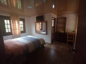 a bedroom with a bed and a dresser and windows at El Rancho Viejo de José, suit de una habitación in Cusúa