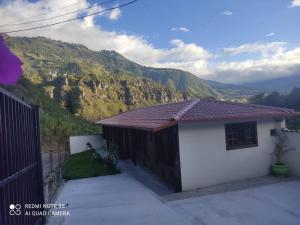 una pequeña casa con una montaña en el fondo en El Rancho Viejo de José, suit de una habitación, en Cusúa