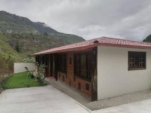 ein kleines Haus mit rotem Dach auf einem Berg in der Unterkunft El Rancho Viejo de José, suit de una habitación in Cusúa