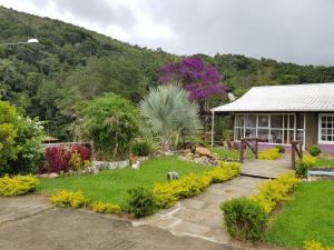 une maison avec un jardin en face dans l'établissement Vale das Maritacas Teresópolis, à Teresópolis