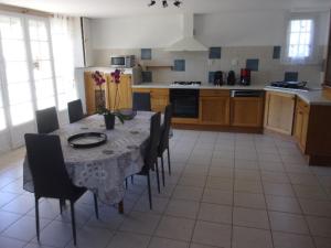 uma cozinha com mesa e cadeiras e uma cozinha com em Appartement du Pont neuf em Villegailhenc