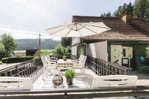 een patio met een tafel en stoelen en een parasol bij Ferienhaus Panoramablick in Niedersalwey