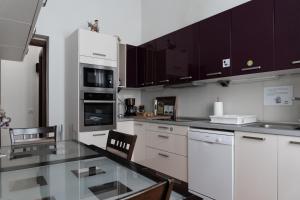 una cucina con armadi bianchi e ripiano in vetro di Santa Ana Suite & Rooms a Las Palmas de Gran Canaria